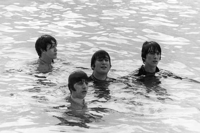 The Beatles tread water in a swimming pool during the filming of the movie