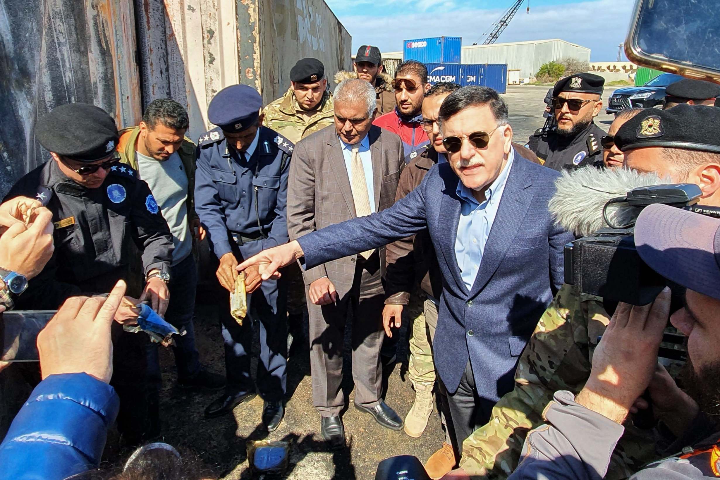 Prime Minister of Libya's UN-recognised Government of National Accord (GNA) Fayez al-Sarraj, flanked by journalists, visits the port in the capital Tripoli after it was hit by rocket fire
