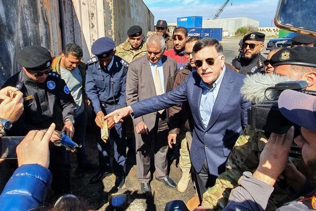 Prime Minister of Libya's UN-recognised Government of National Accord (GNA) Fayez al-Sarraj, flanked by journalists, visits the port in the capital Tripoli after it was hit by rocket fire