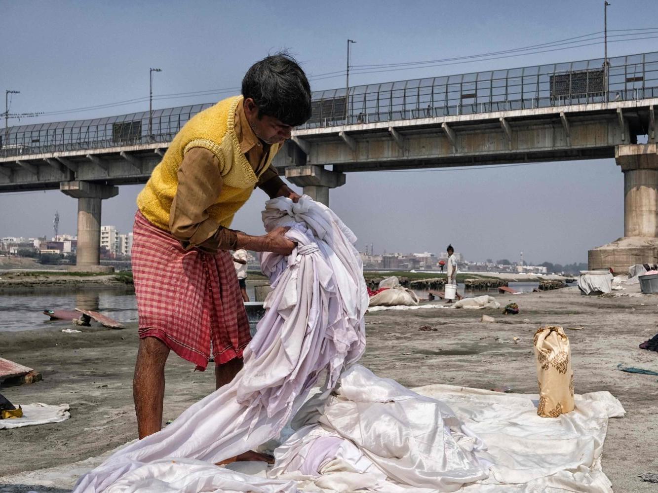 In this picture taken on February 12 2020 a man washes clothes on the banks of the Yamuna river in Agra