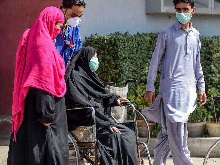 A paramedic helps a victim on a wheelchair at a hospital, a day after an apparent toxic gas leak in Pakistan's port city of Karachi