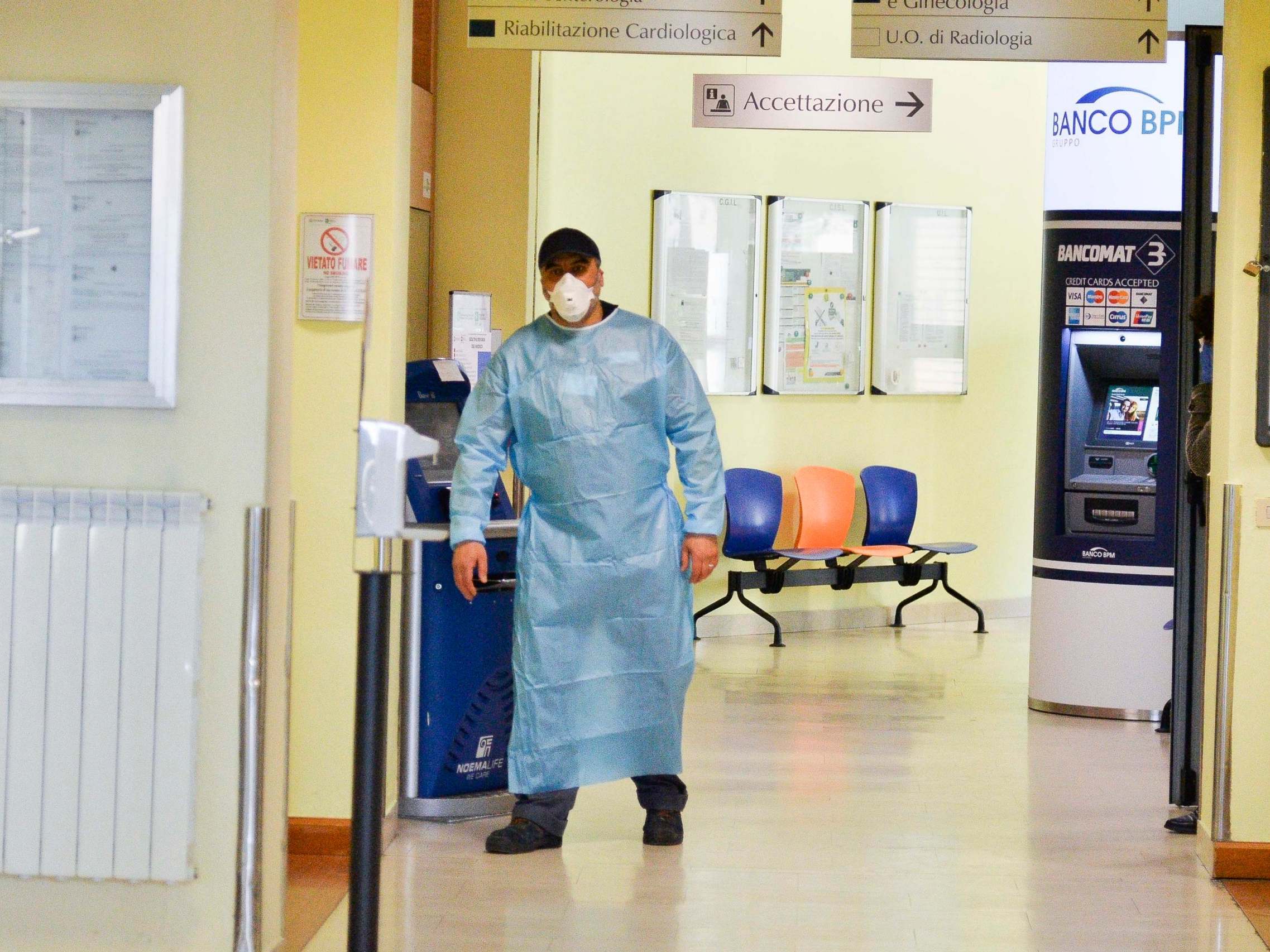 A health worker wearing a face mask walks in a corridor of the Codogno Civic Hospital in Lodi, northern Italy
