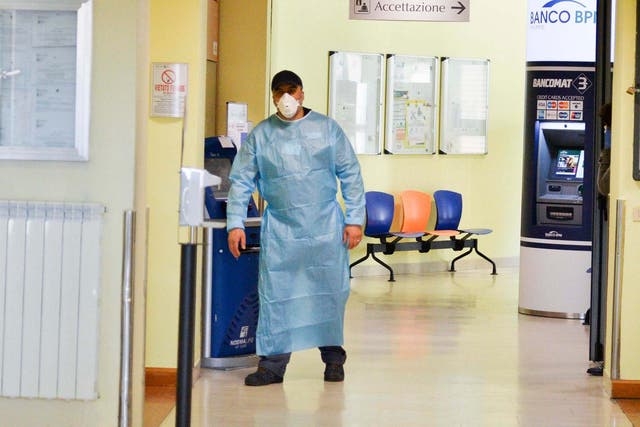 A health worker wearing a face mask walks in a corridor of the Codogno Civic Hospital in Lodi, northern Italy