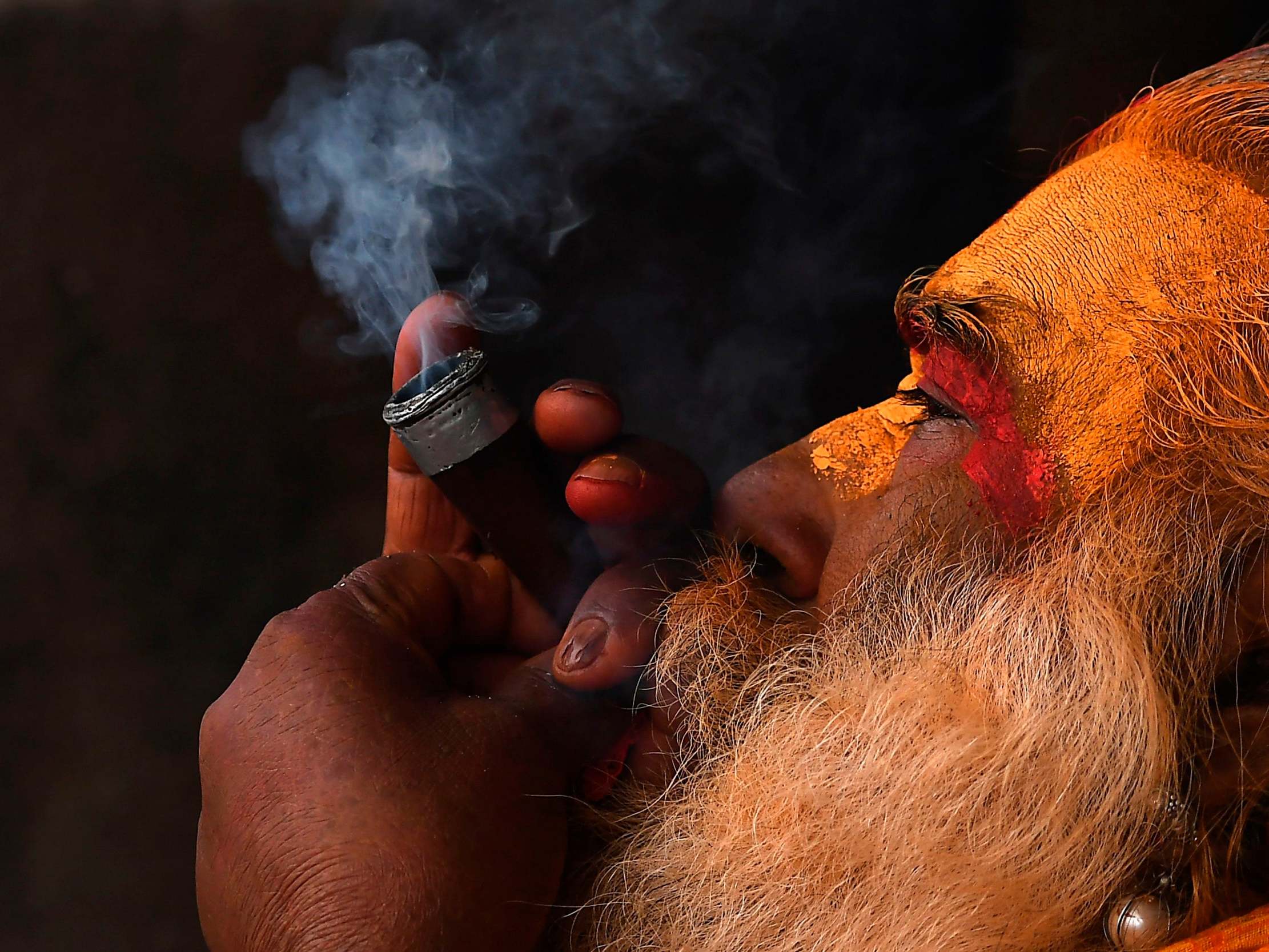 A sadhu (Hindu holy man) smokes marijuana using a 'chillum', a traditional clay pipe, during the Maha Shivaratri festival