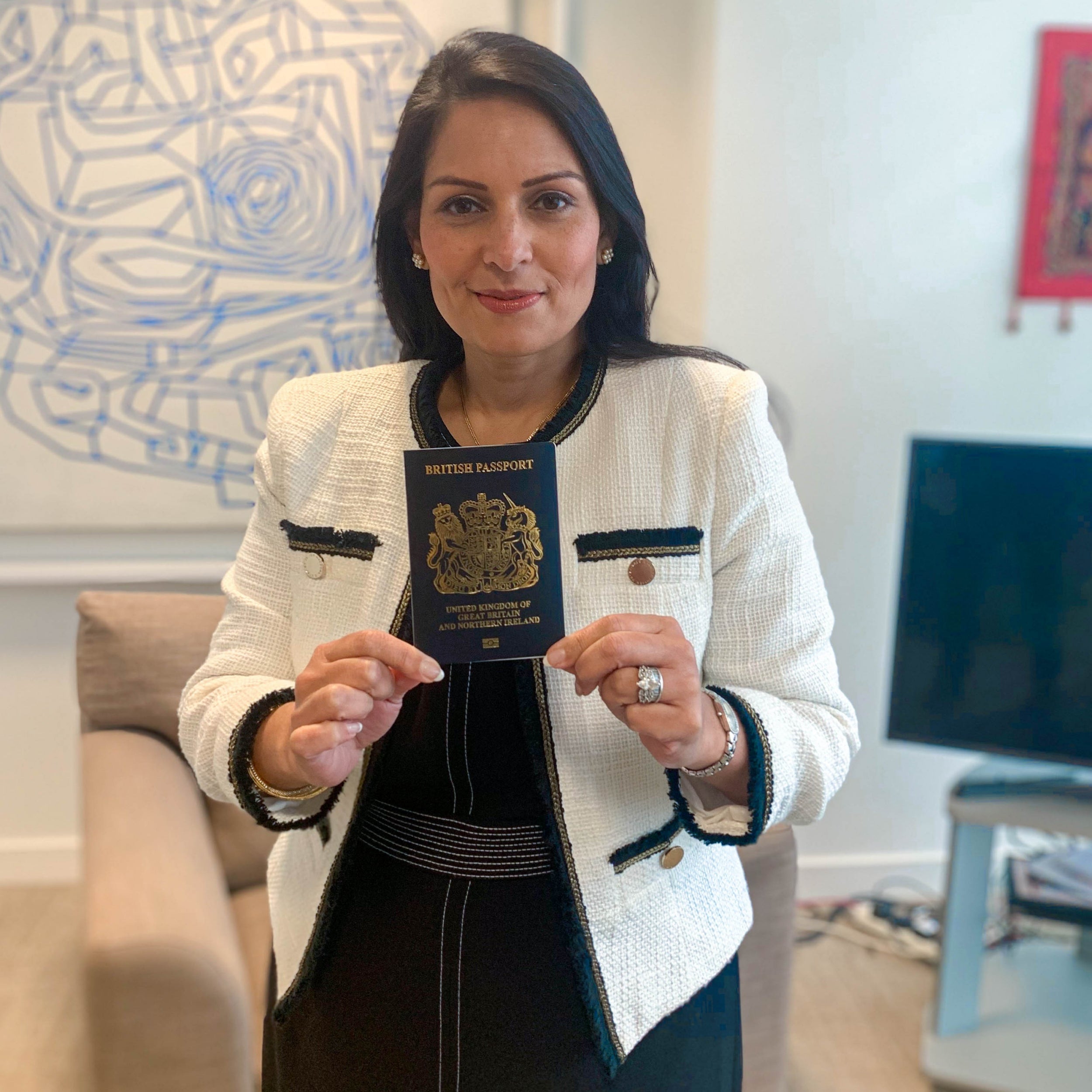 Patel pictured with one of the new blue passports, which will be issued from next month