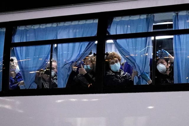 US citizens wave from a bus 17 February 2020 as they leave the Diamond Princess cruise ship docked in Yokohama, Japan