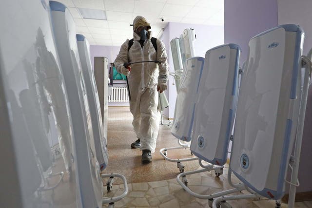 A worker in a chemical suit sprays disinfectant in a quarantine facility at the Gradostroitel health resort near the city of Tyumen after a 14-day quarantine for Russian nationals who were evacuated from Wuhan
