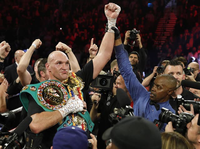 Tyson Fury celebrates with the WBC and Ring Magazine titles