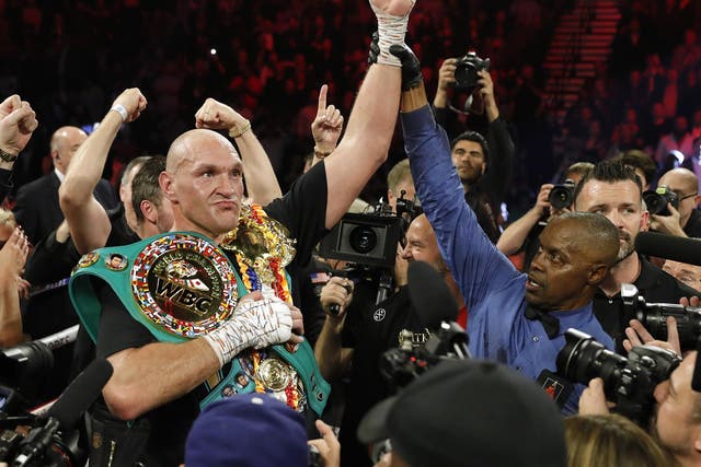 Tyson Fury celebrates with the WBC and Ring Magazine titles