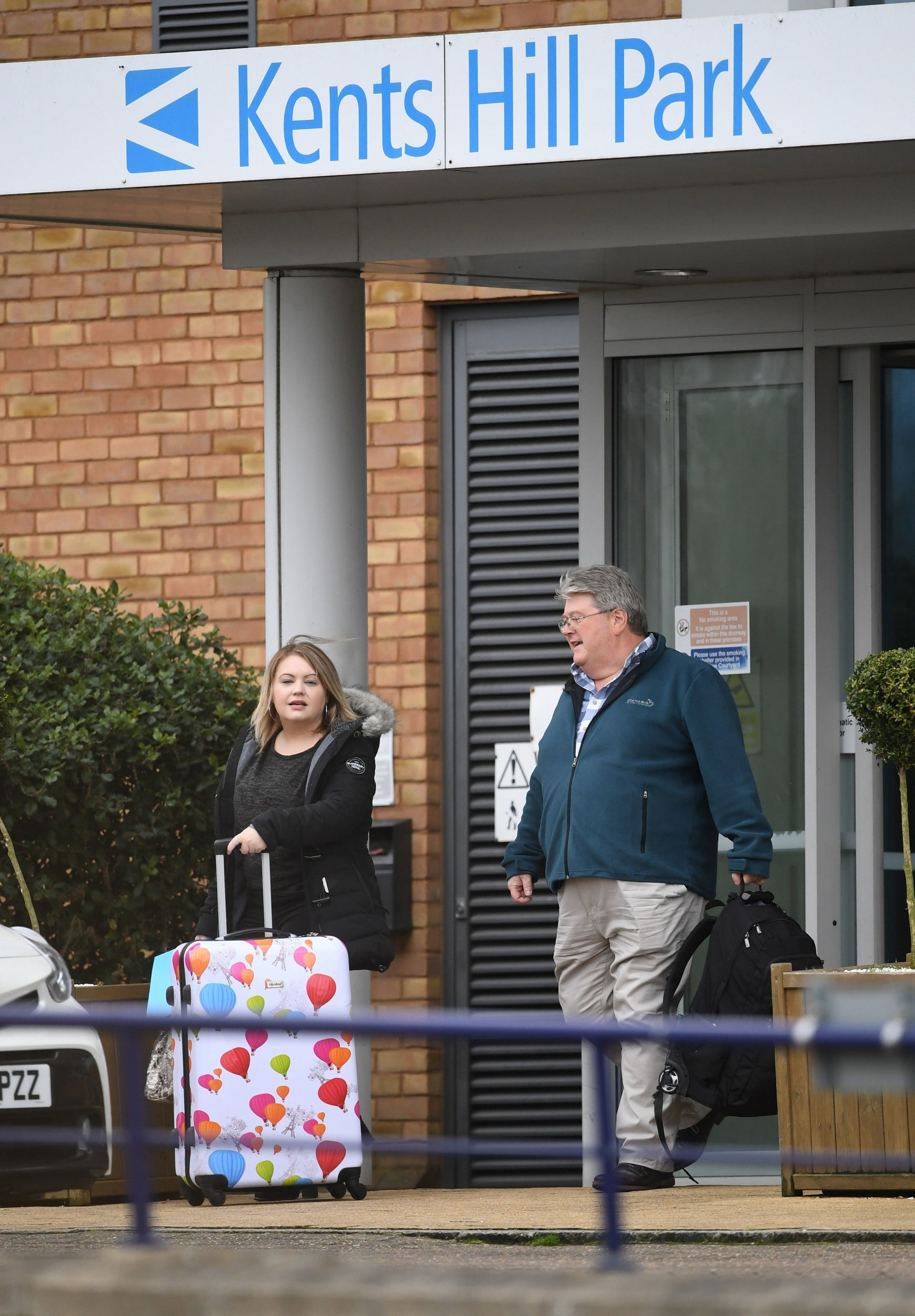 Two people get into a taxi at Kents Hill Park Training and Conference Centre in Milton Keynes