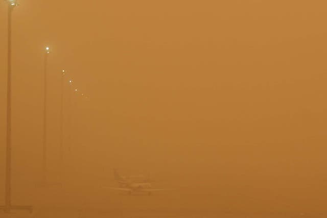 Planes are seen parked on the tarmac during a sandstorm blown over from North Africa known as "calima" at Las Palmas Airport