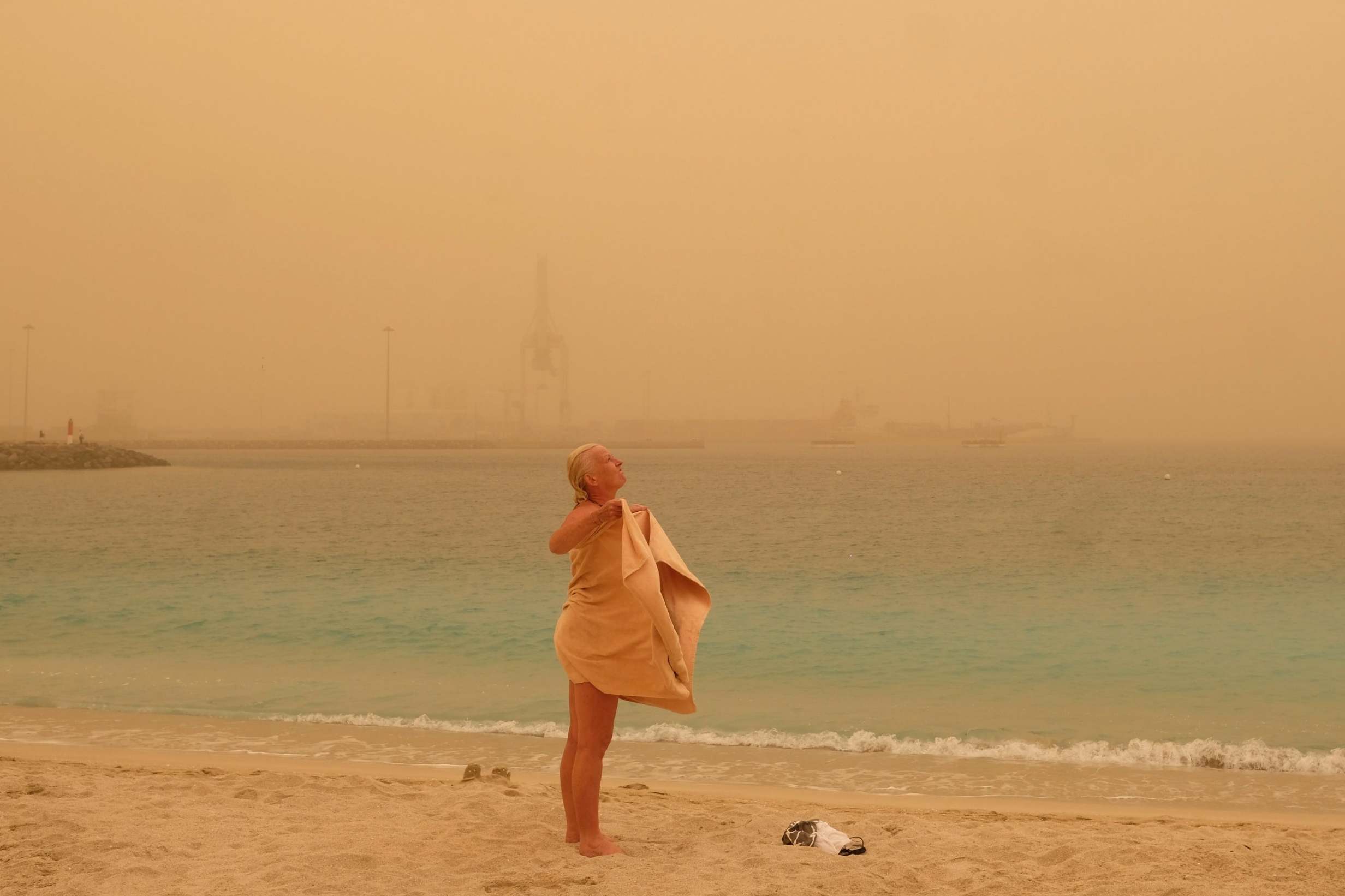 A tourist dries off after a swim in Fuerteventura, which has been hit by large amounts of dust that has blown over from the Sahara