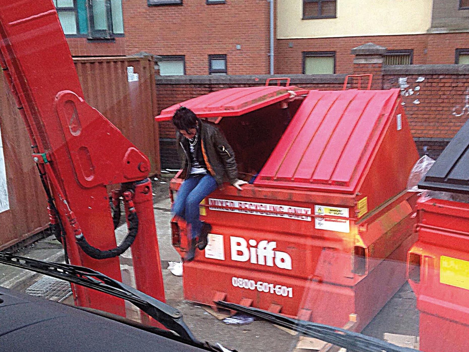 A rough sleeper emerges from a waste unit