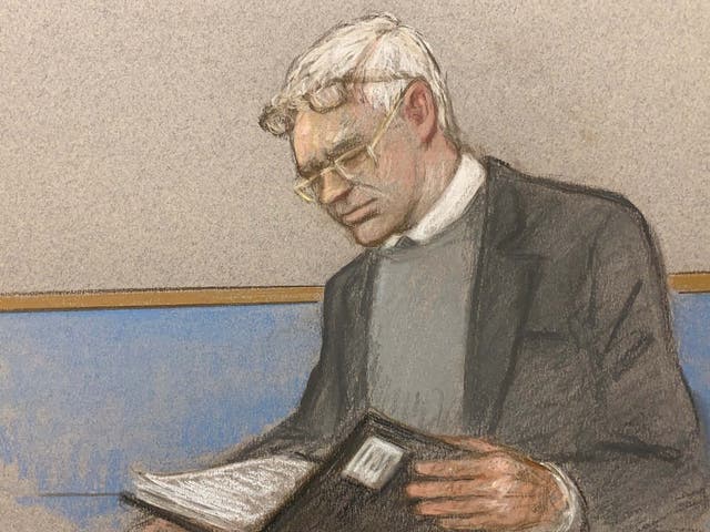 Julian Assange wearing two pair of glasses in seen at court during an extradition hearing