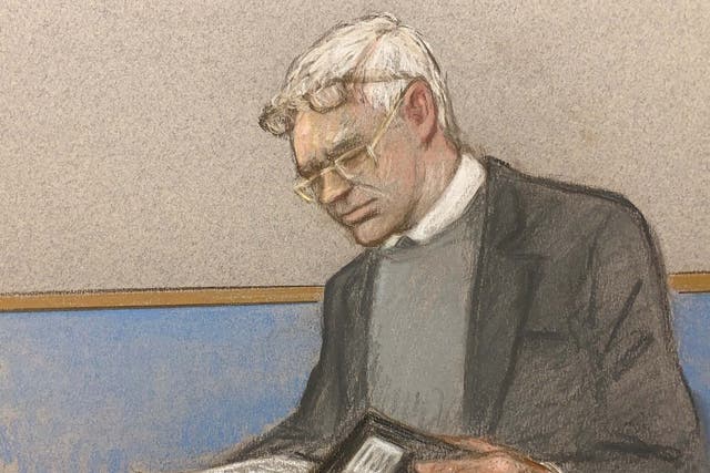 Julian Assange wearing two pair of glasses in seen at court during an extradition hearing