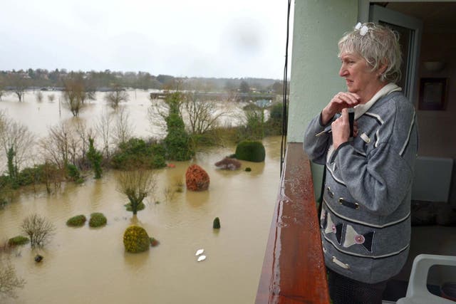 A resident living in a flat near the River Severn in Shrewsbury looks out over flooded gardens