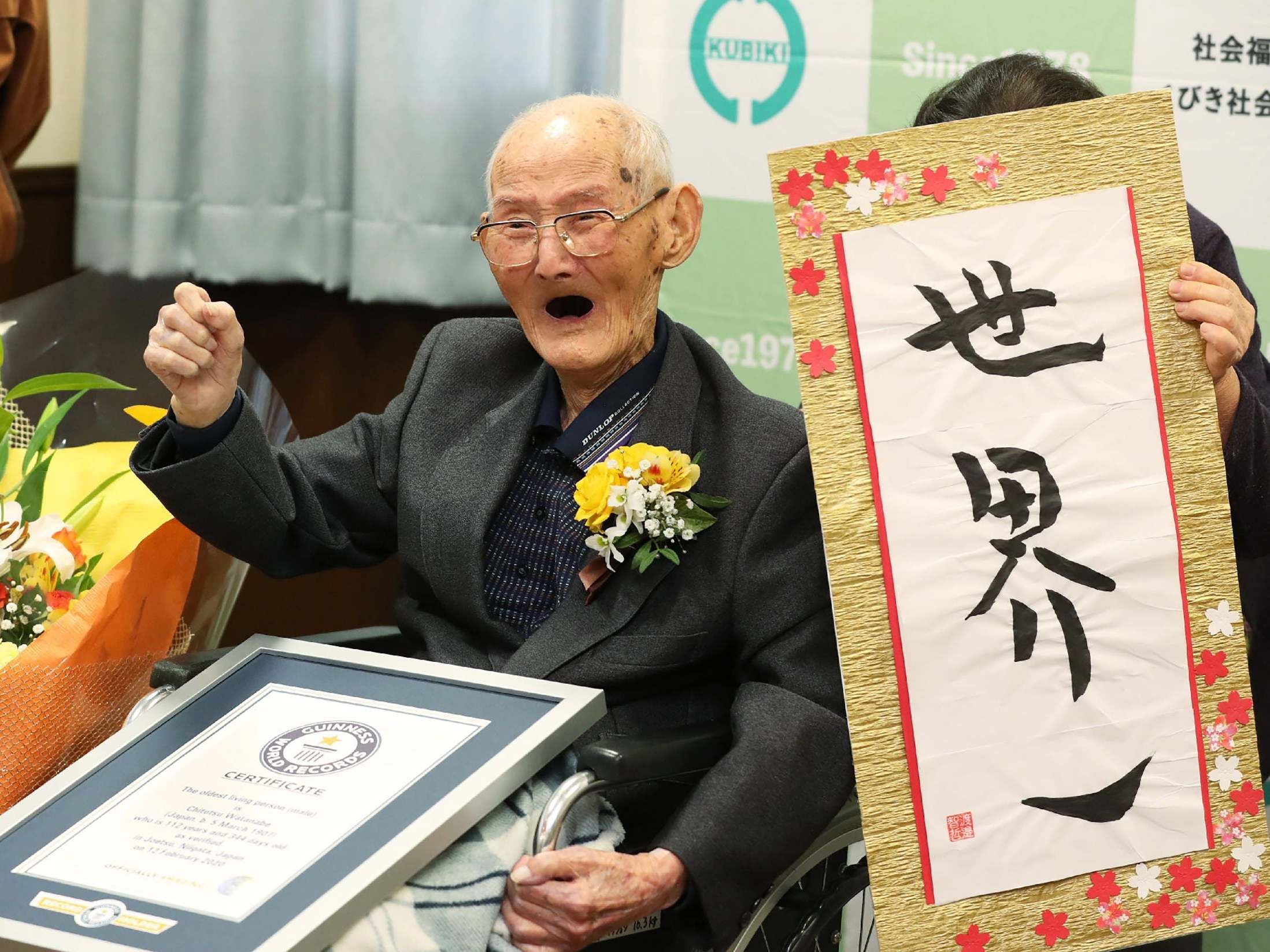112-year-old Japanese man Chitetsu Watanabe poses next to the calligraphy he wrote after being recorded as the world's oldest living male by Guinness World Records, in Joetsu, Niigata prefecture, northern Japan, 12 February, 2020.