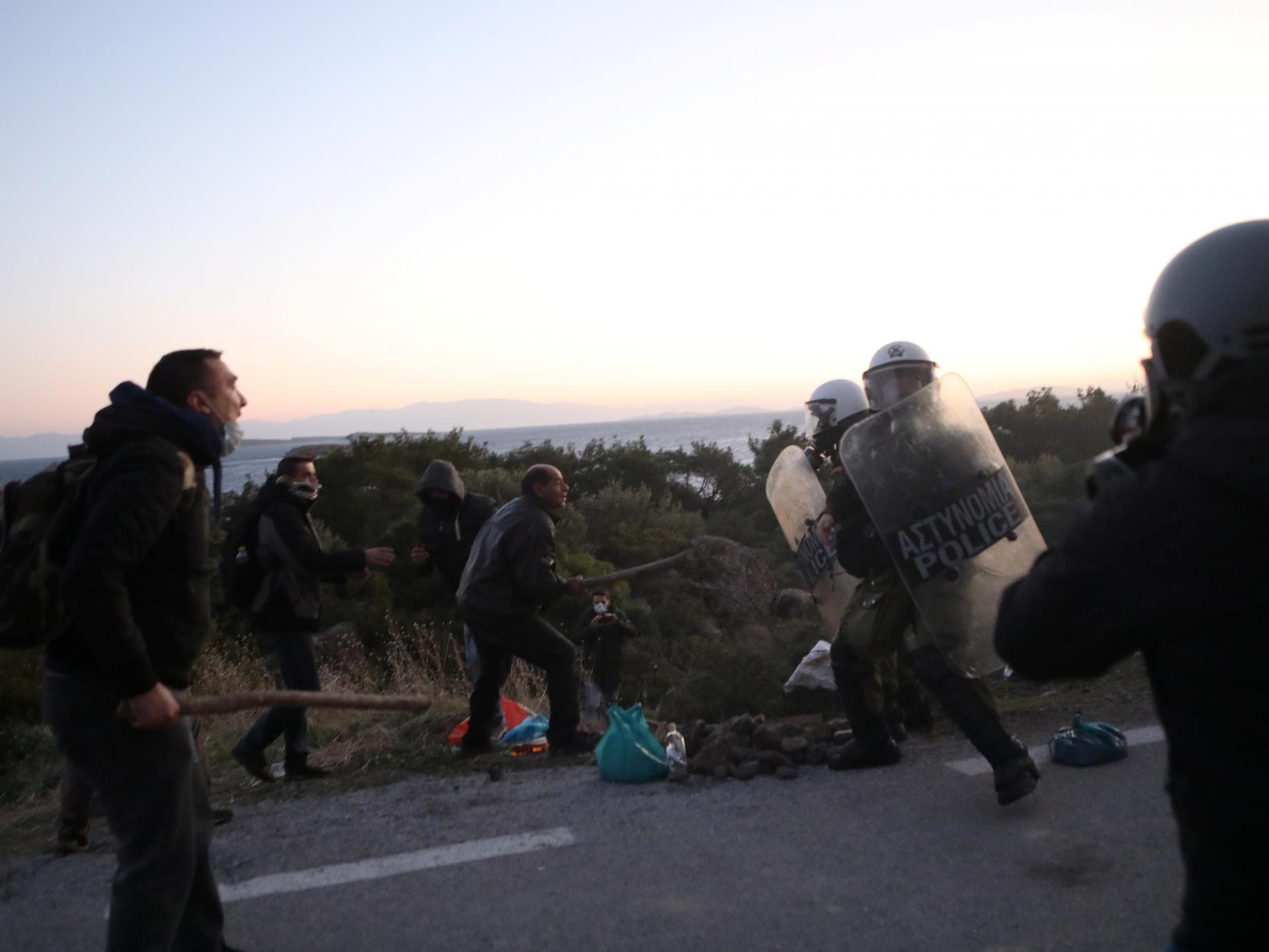 Locals scuffle with riot police on Lesbos during protests against a planned new migrant centre