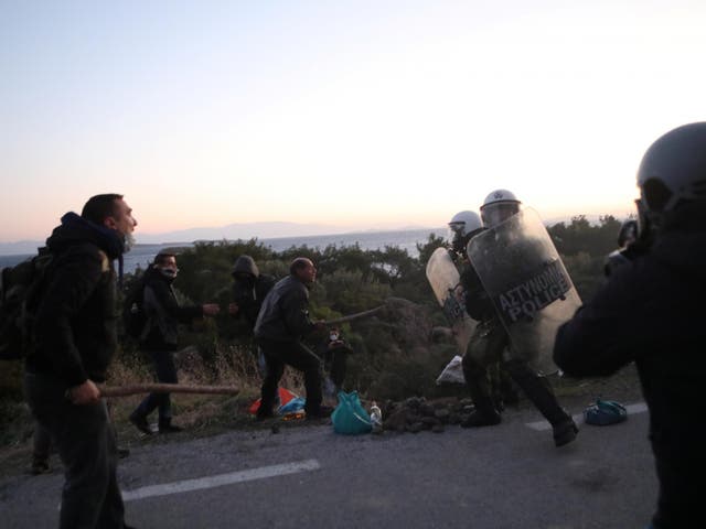 Locals scuffle with riot police on Lesbos during protests against a planned new migrant centre