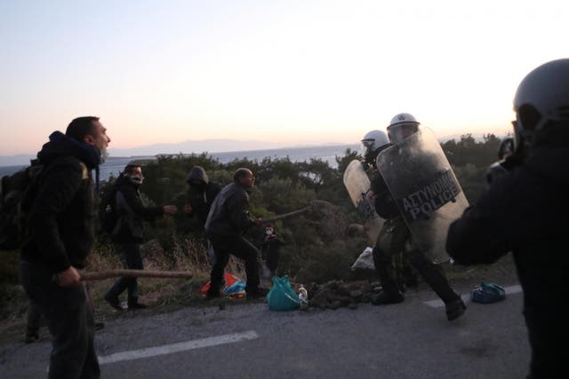 Locals scuffle with riot police on Lesbos during protests against a planned new migrant centre