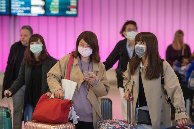 Passengers wear protective masks at Los Angeles International Airport to protect against coronavirus. CDC officials said Tuesday it probably will become a pandemic