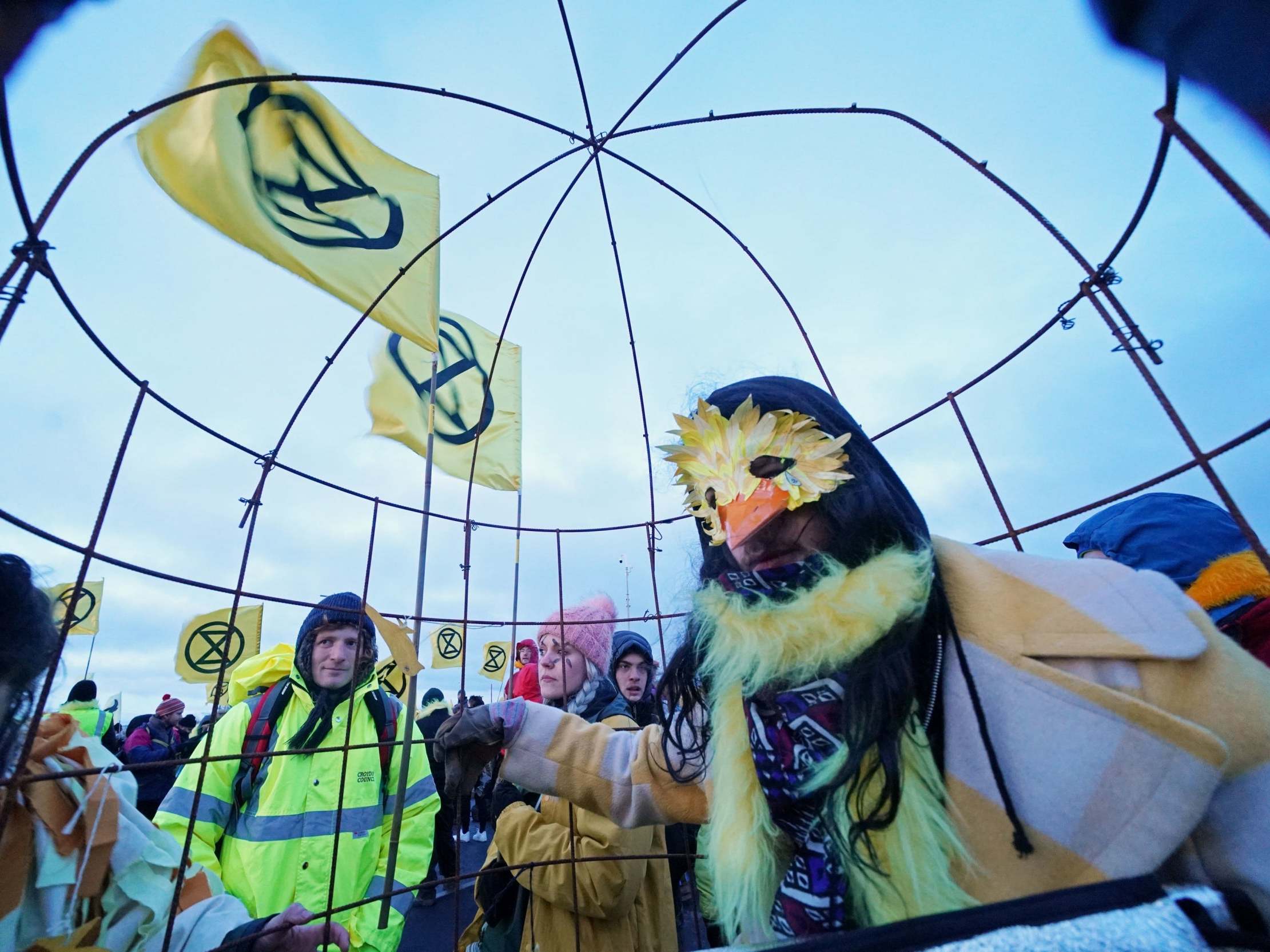 A person dressed as a canary inside a cage during an Extinction Rebellion protest at Bradley open-cast coal mine in County Durham