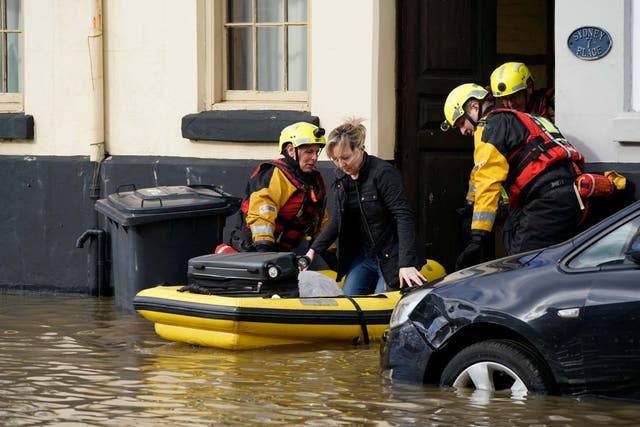 Rescue workers help a woman to safety in flood waters in Bewdley, where river levels could break a 20-year record as rain continues to fall