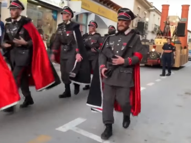Men dressed as Nazi officers parade in front of a float in Campo de Criptana, Spain, on February 24, 2020.