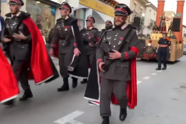 Men dressed as Nazi officers parade in front of a float in Campo de Criptana, Spain, on February 24, 2020.