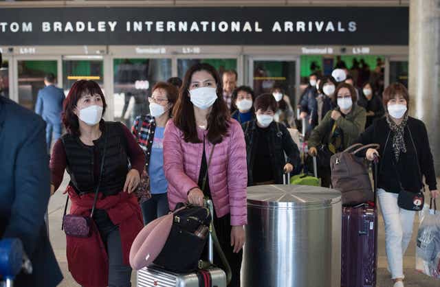 Passengers on a flight from Asia arrived to Los Angeles International Airport waring face masks. US health officials recommend people to only wear masks if they are sick