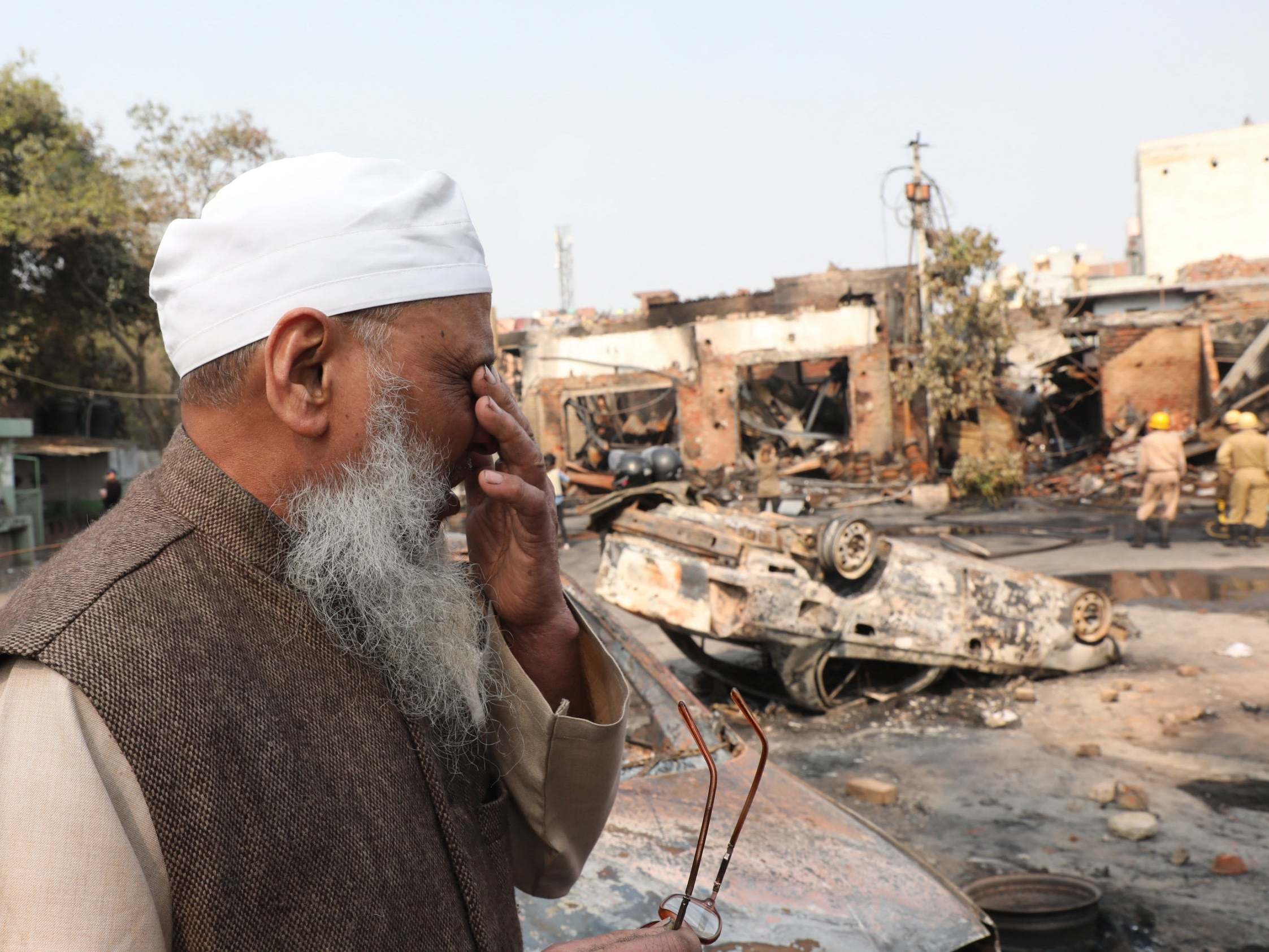 Indian Muslim man reacts as he looks at a burnt market clashes in New Delhi