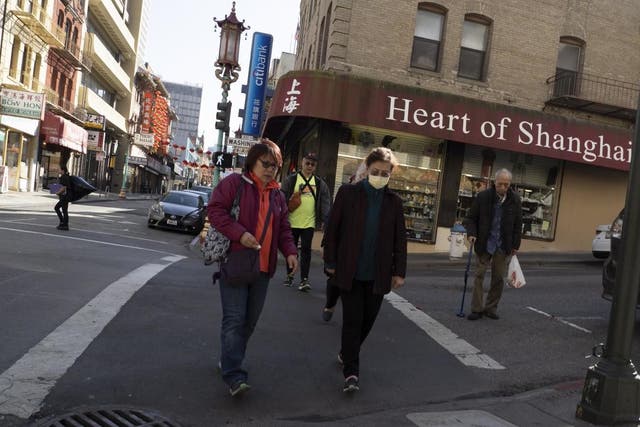 A woman wears a protective mask while walking through unbusy Chinatown in San Francisco on 26 February 2020