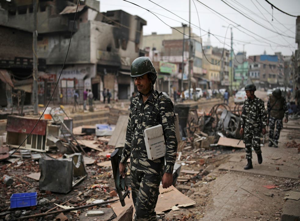 Indian paramilitary soldiers patrol streets vandalised in the religious violence on Thursday in Delhi