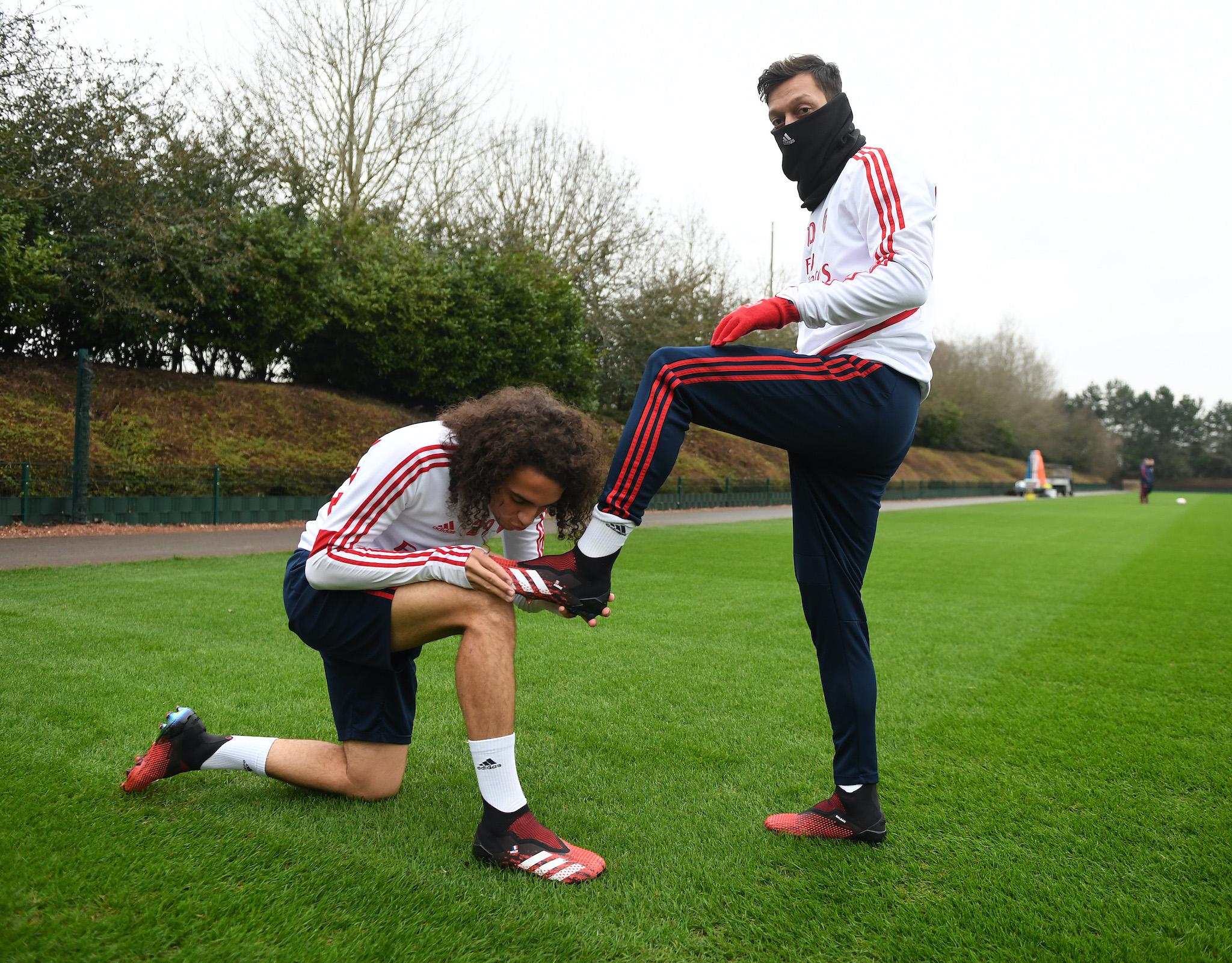 Matteo Guendouzi kisses (R) Mesut Ozil's new adidas predator boot before a training session at London Colney on January 24, 2020 in St Albans, England