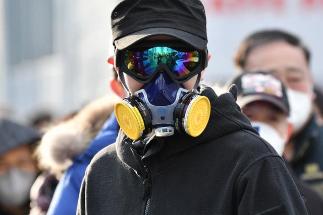 A man wears a mask and goggles as he waits in line to buy face masks from a post office near the Daegu branch of the Shincheonji Church of Jesus in Daegu South Korean on 27 February February 2020