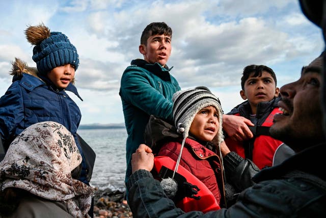 Afghan refugees disembark from a dinghy on the Greek island of Lesbos