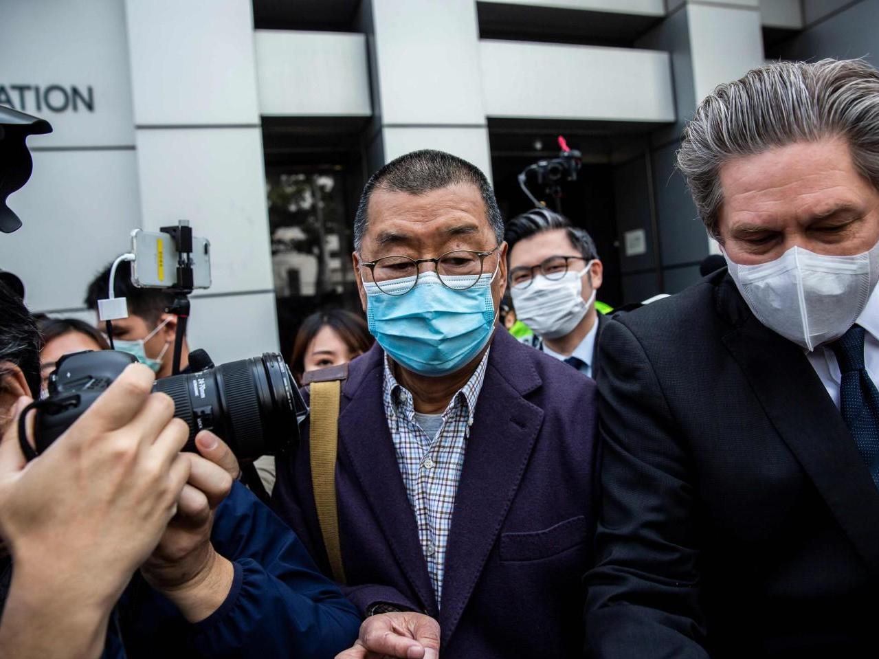 Hong Kong media tycoon and founder of Apple Daily newspaper Jimmy Lai, centre, leaves the Kowloon City police station in Hong Kong on 28 February 2020