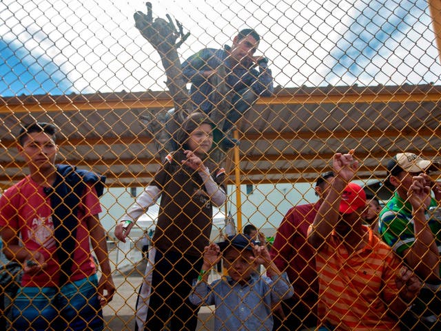 Central American migrants remain at a warehouse used as shelter in Mexico along US border