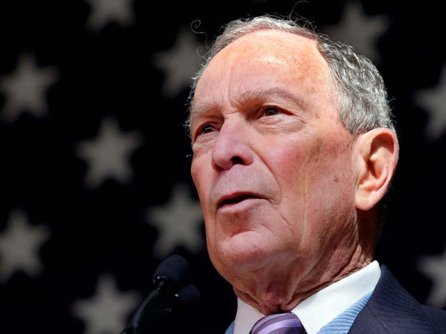 Mike Bloomberg speaks in front of an American flag