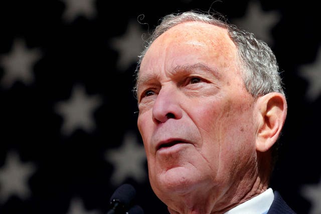 Mike Bloomberg speaks in front of an American flag