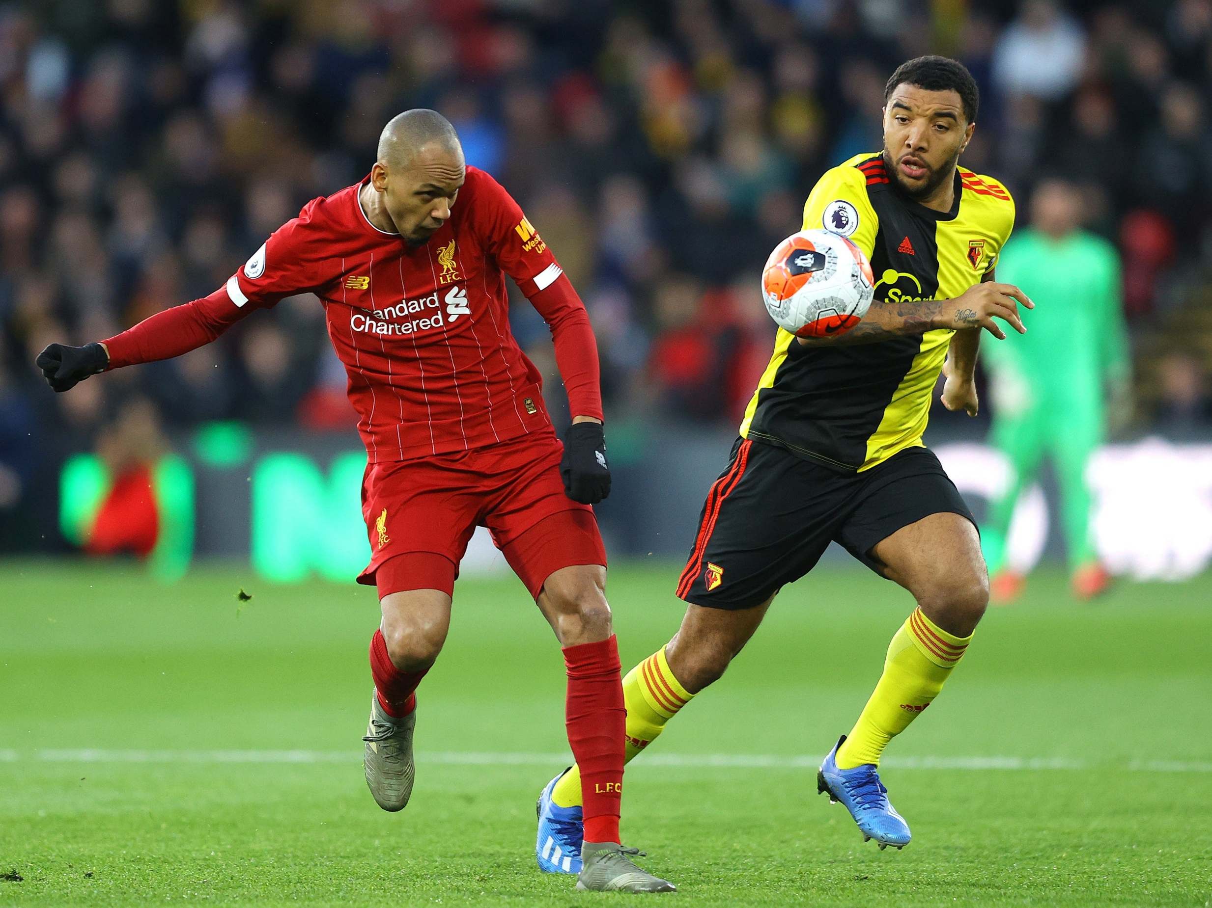 Fabinho and Troy Deeney battle for the ball in midfield