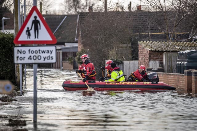Rescue workers in the flooded village of East Cowick, Yorkshire, after heavy rain and strong winds brought by Storm Jorge battered the UK overnight.