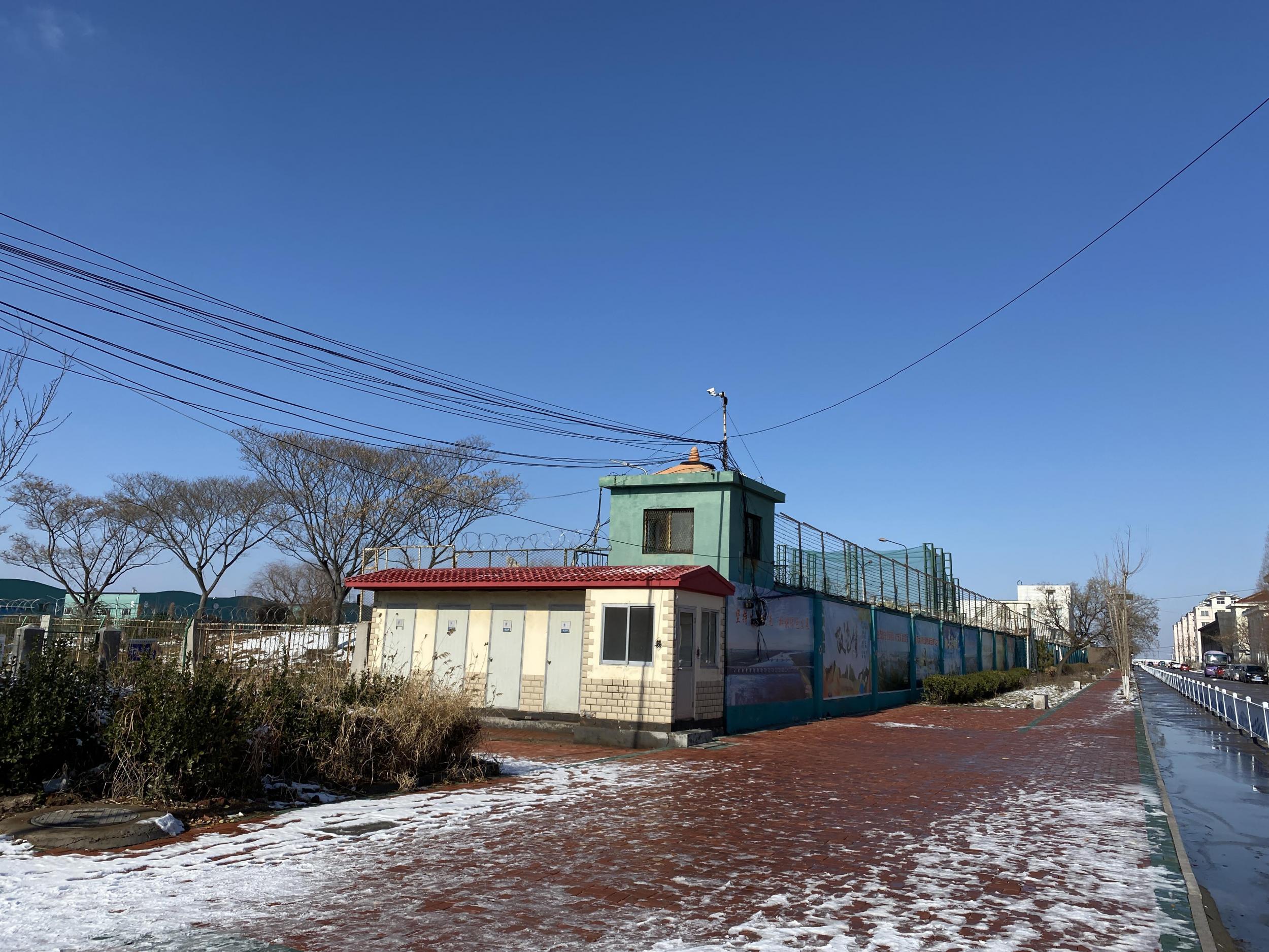 Factories Uighurs are sent to, like the Qingdao Taekwang Shoes Co. one shown, have watchtowers with cameras and high barbed-wire fences atop walls (Anna Fifield)