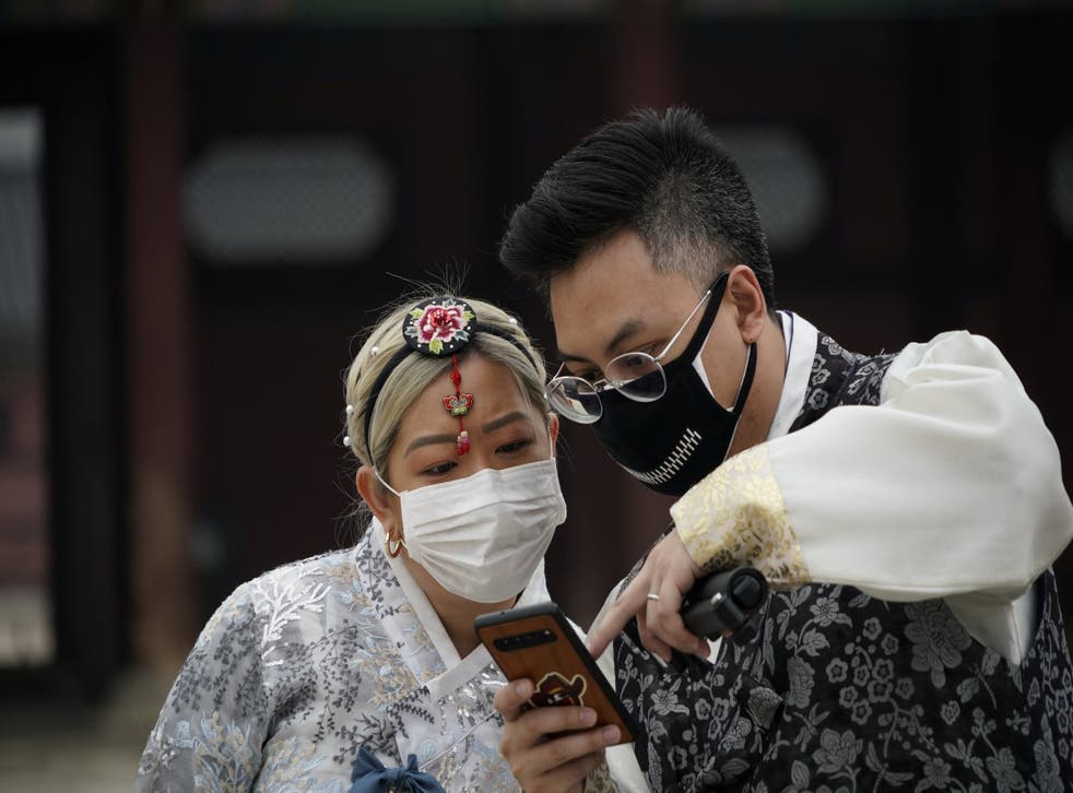 A couple in Korean traditional costumes, Hanbok, wearing masks to prevent contacting the coronavirus