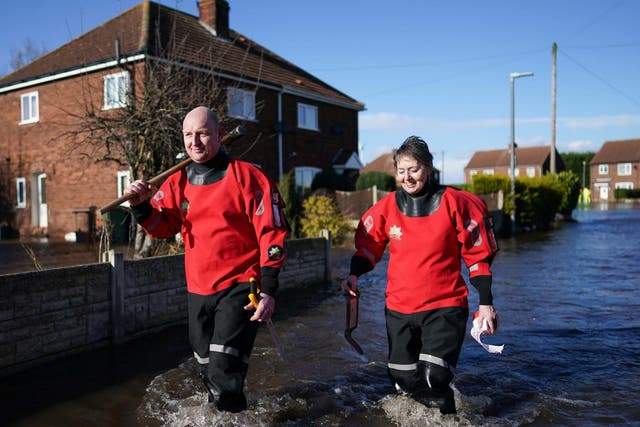 Members of Humber Fire and Rescue Service walk through flood water after the River Aire bursts its banks in East Cowick, Yorkshire, on 29 February 2020.