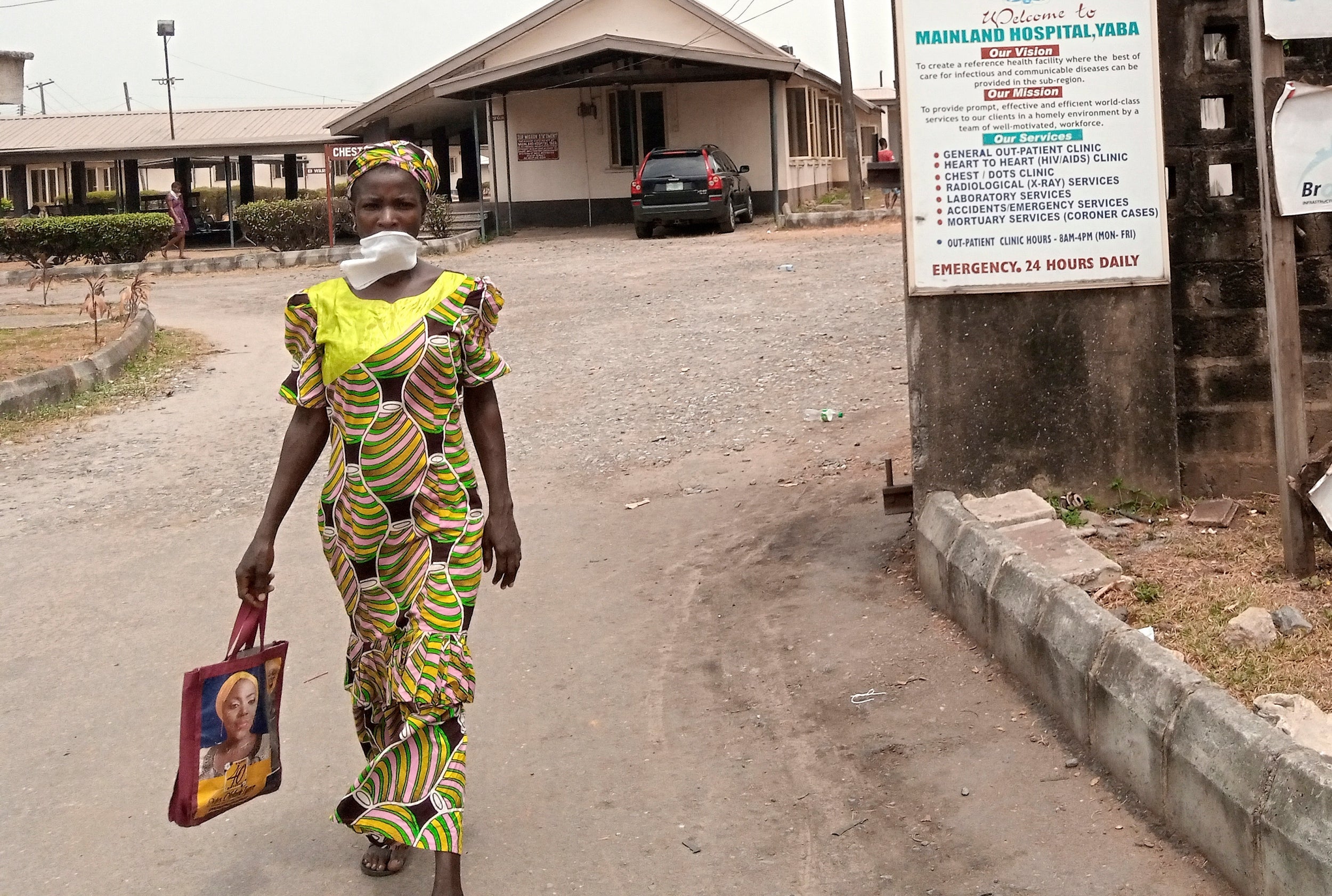 A Nigerian woman walks with a mask at the Yaba Mainland hospital where the first case of coronavirus was treated