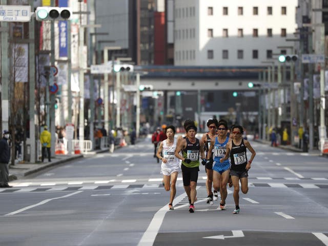 Runners race through the empty streets in the city centre of Tokyo during the marathon