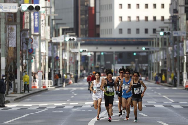 Runners race through the empty streets in the city centre of Tokyo during the marathon