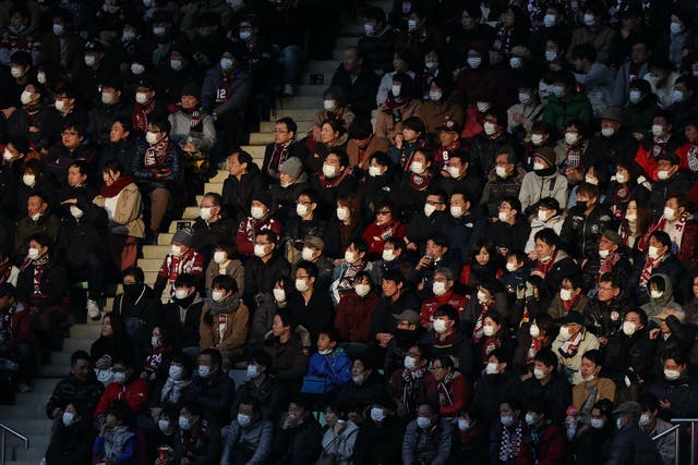 This picture taken on February 23, 2020 shows audience members wearing face masks at a J.League football match between Vissel Kobe and Yokohama F. Marinos in Kobe