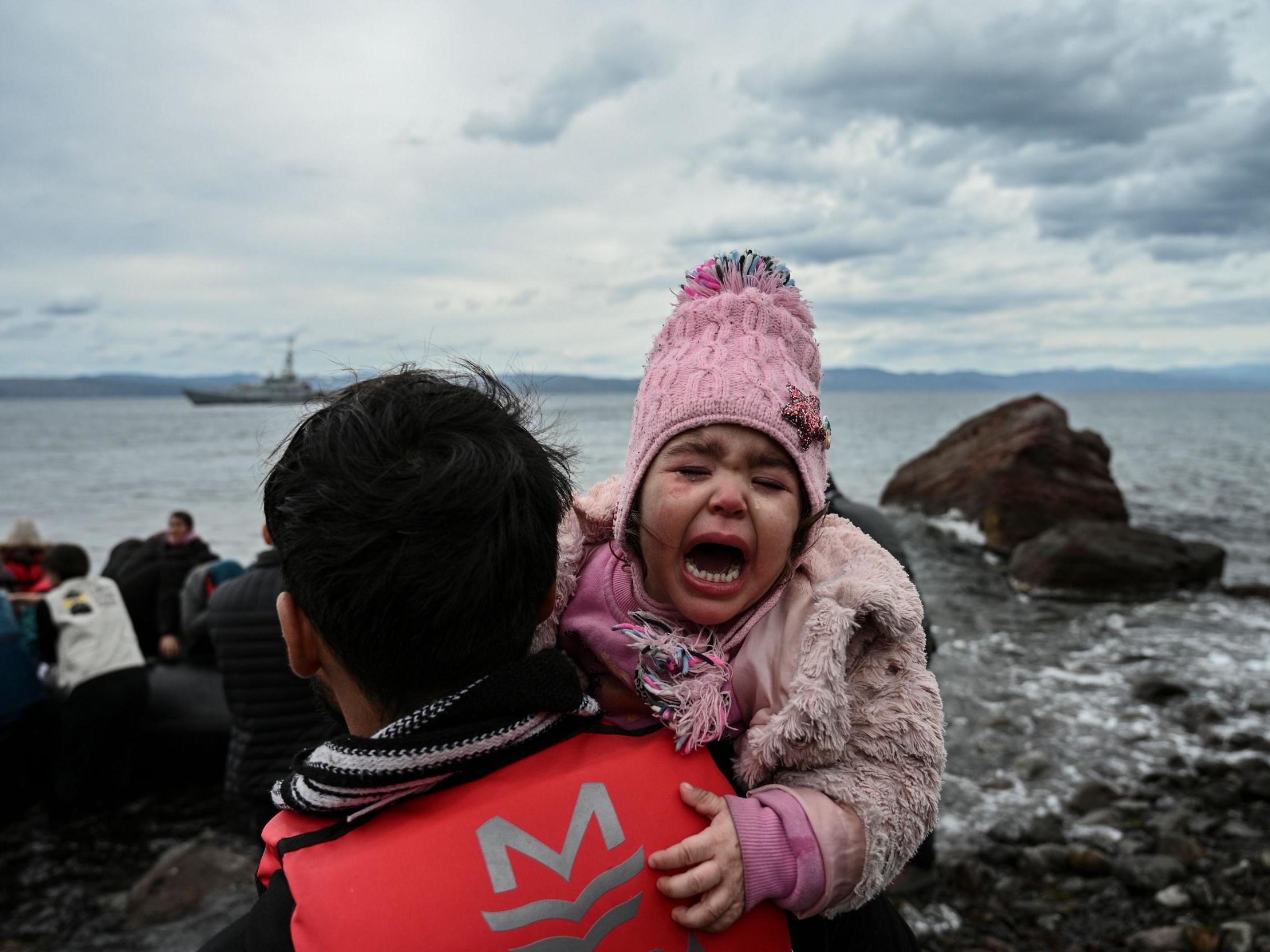 A child cries as a dinghy with 54 Afghan refugees lands ashore the Greek island of Lesbos